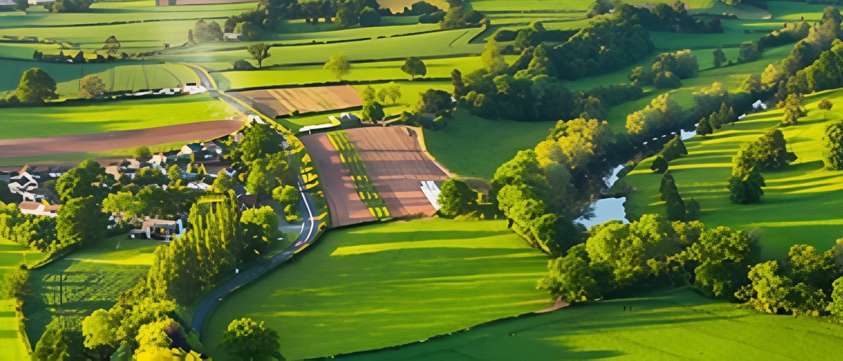 An aerial rural landscape: a small village set among fields, with a river running through it