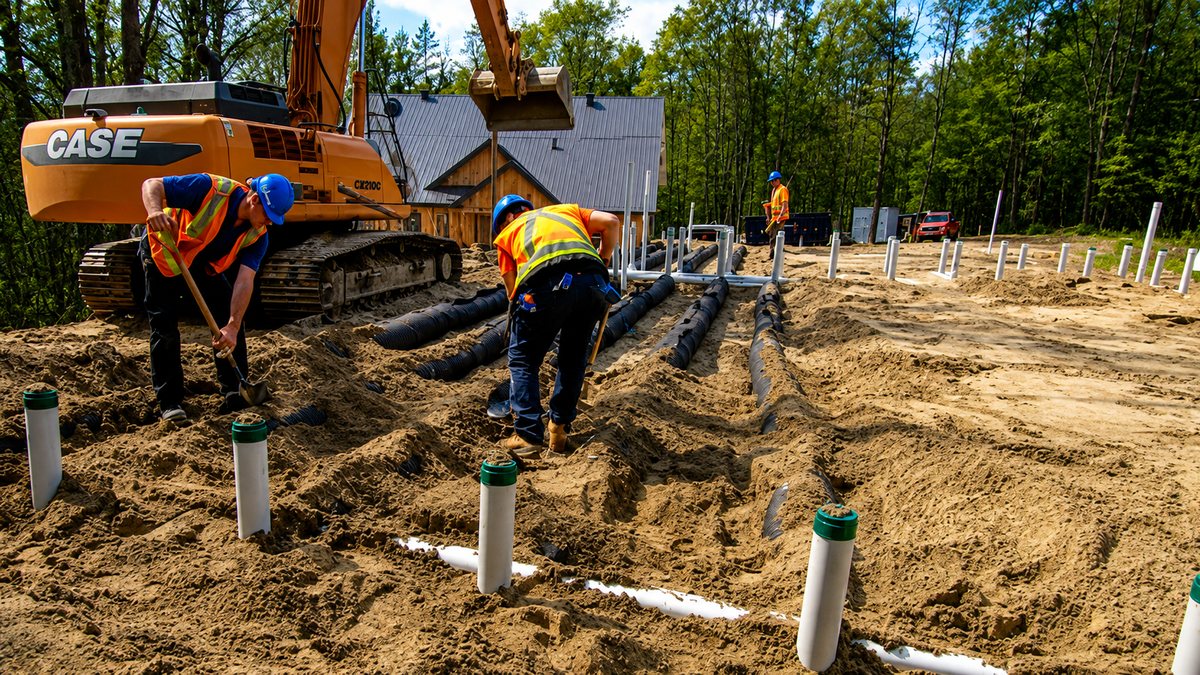 Treatment line pipes being laid with an excavator and field crew